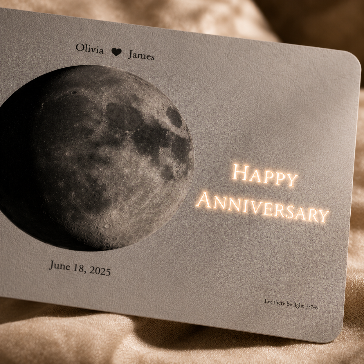 Close-up of personalized wedding day moon hidden message film card on cream velvet with names Olivia heart James June 18