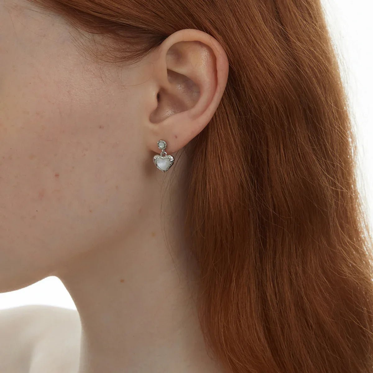 Pearl Heart Drop Earrings with Ornate Frame — right-ear worn close-up showing the two-part drop construction
