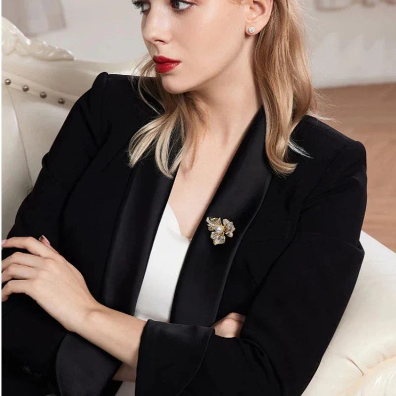 Pearl and Cubic Zirconia Plum Blossom Brooch — seated model wearing the brooch on a black blazer