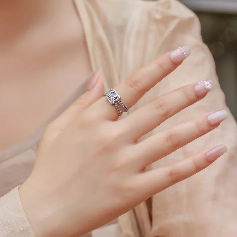 Princess-cut Alexandrite halo ring with a split shank, shown worn in a close lifestyle view