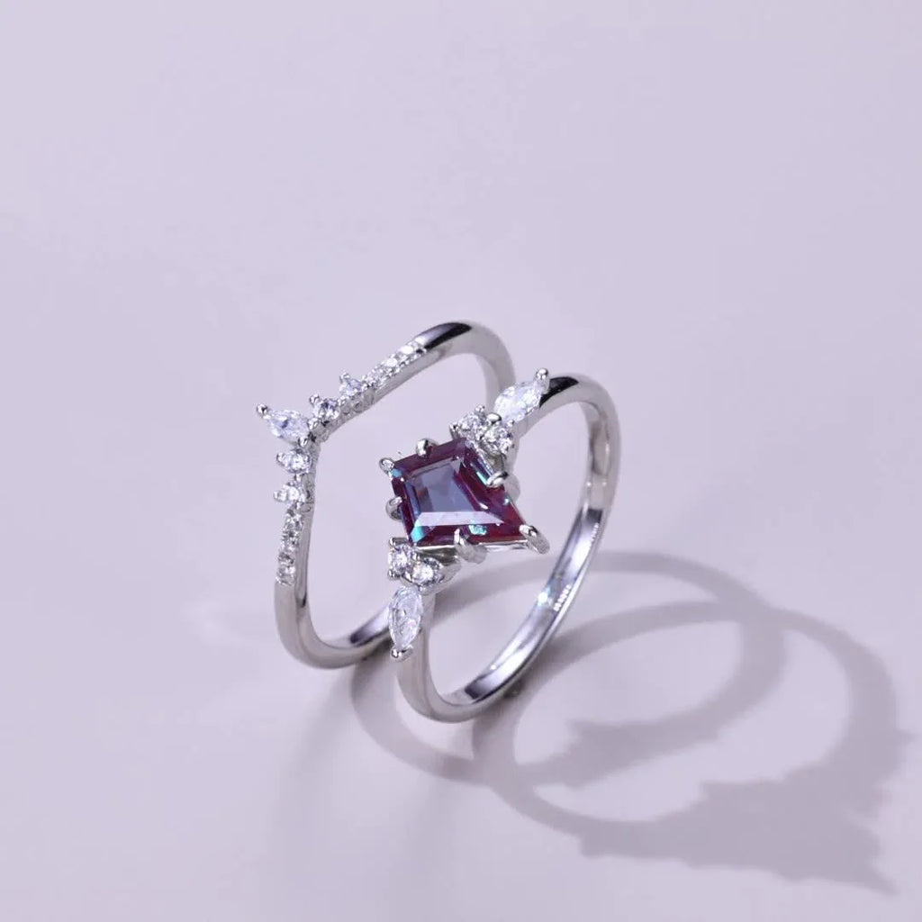 Princess-cut Alexandrite two-band ring with clear accents, angled product view on a colored background