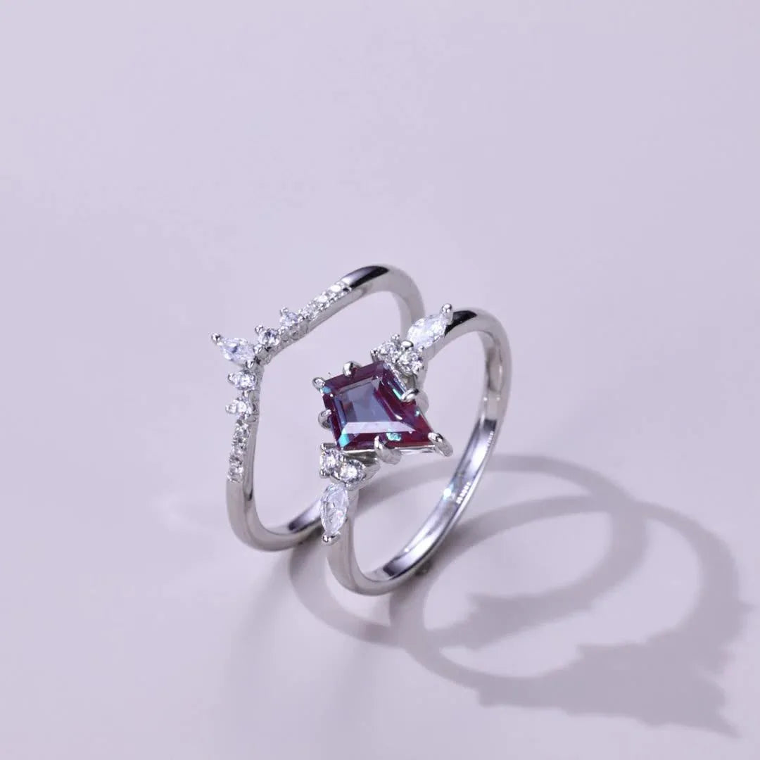 Princess-cut Alexandrite two-band ring with clear accents, angled product view on a colored background