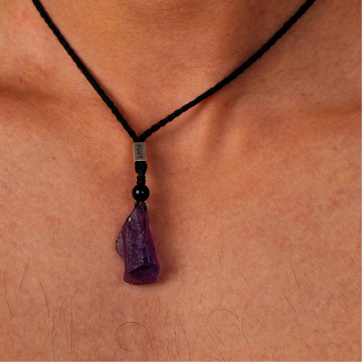 raw amethyst crystal cord necklace worn at the neckline in a close-up