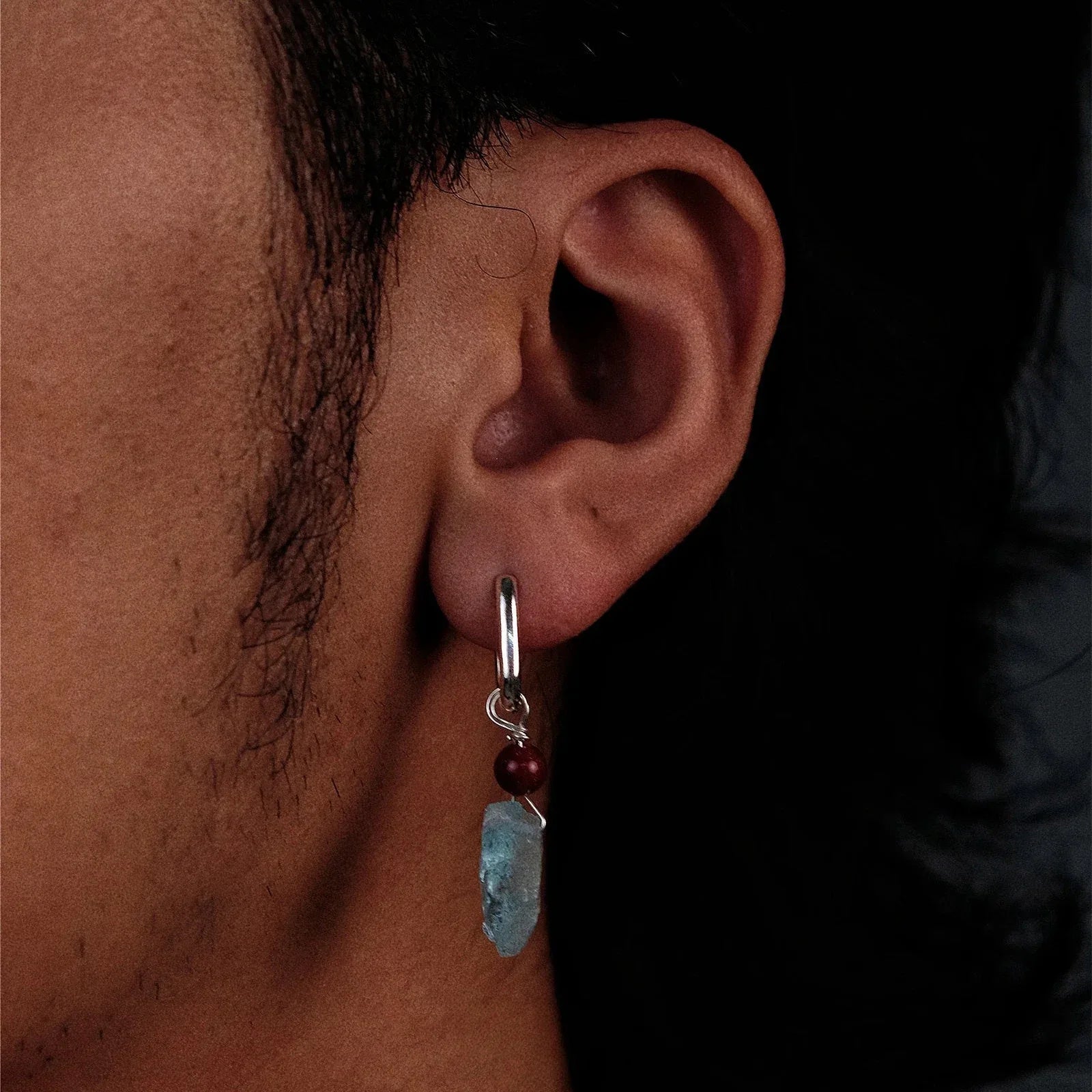 Raw Aquamarine and Cinnabar Drop Earrings worn on the ear in a close-up