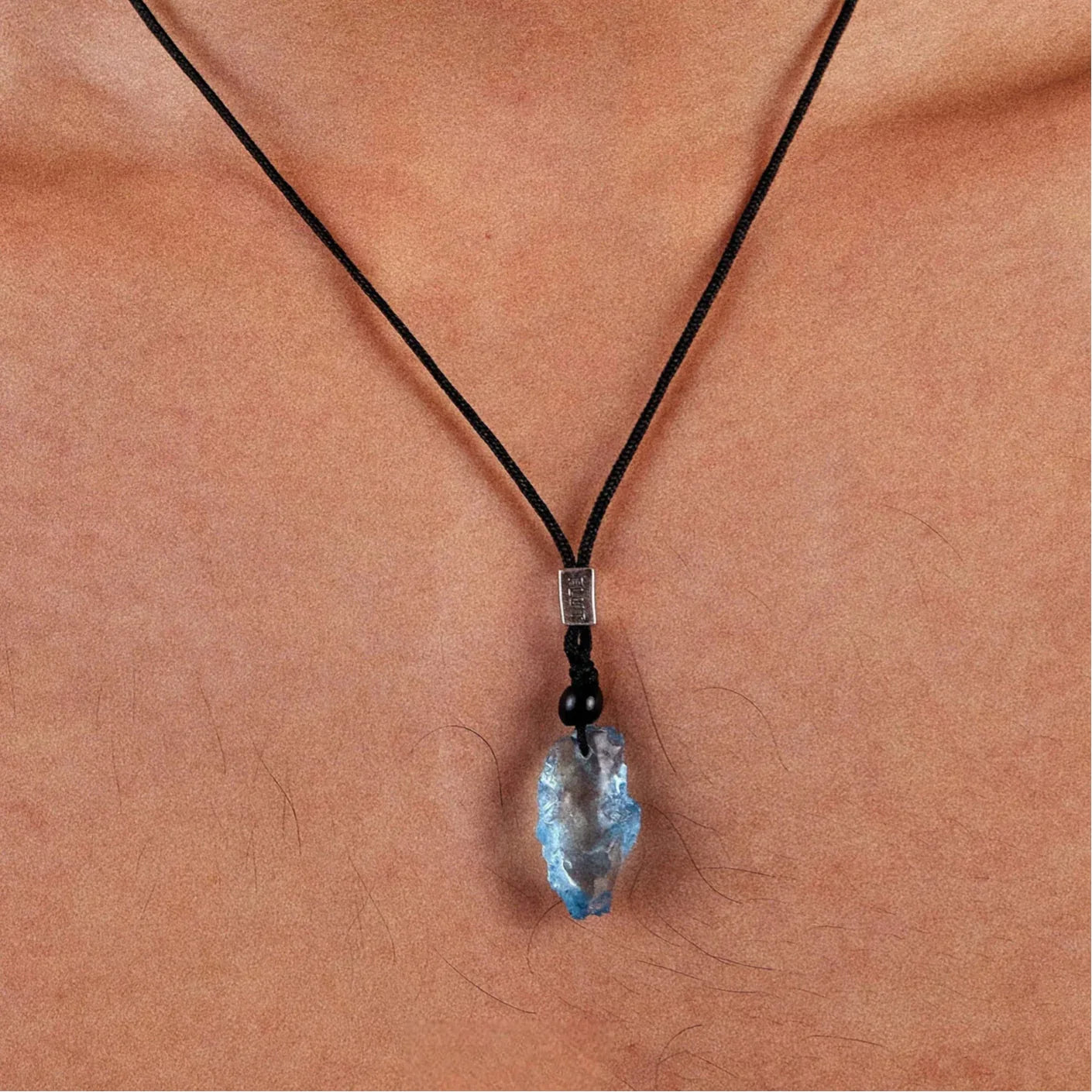 Raw Aquamarine Cord Pendant Necklace worn at the neckline in a close-up
