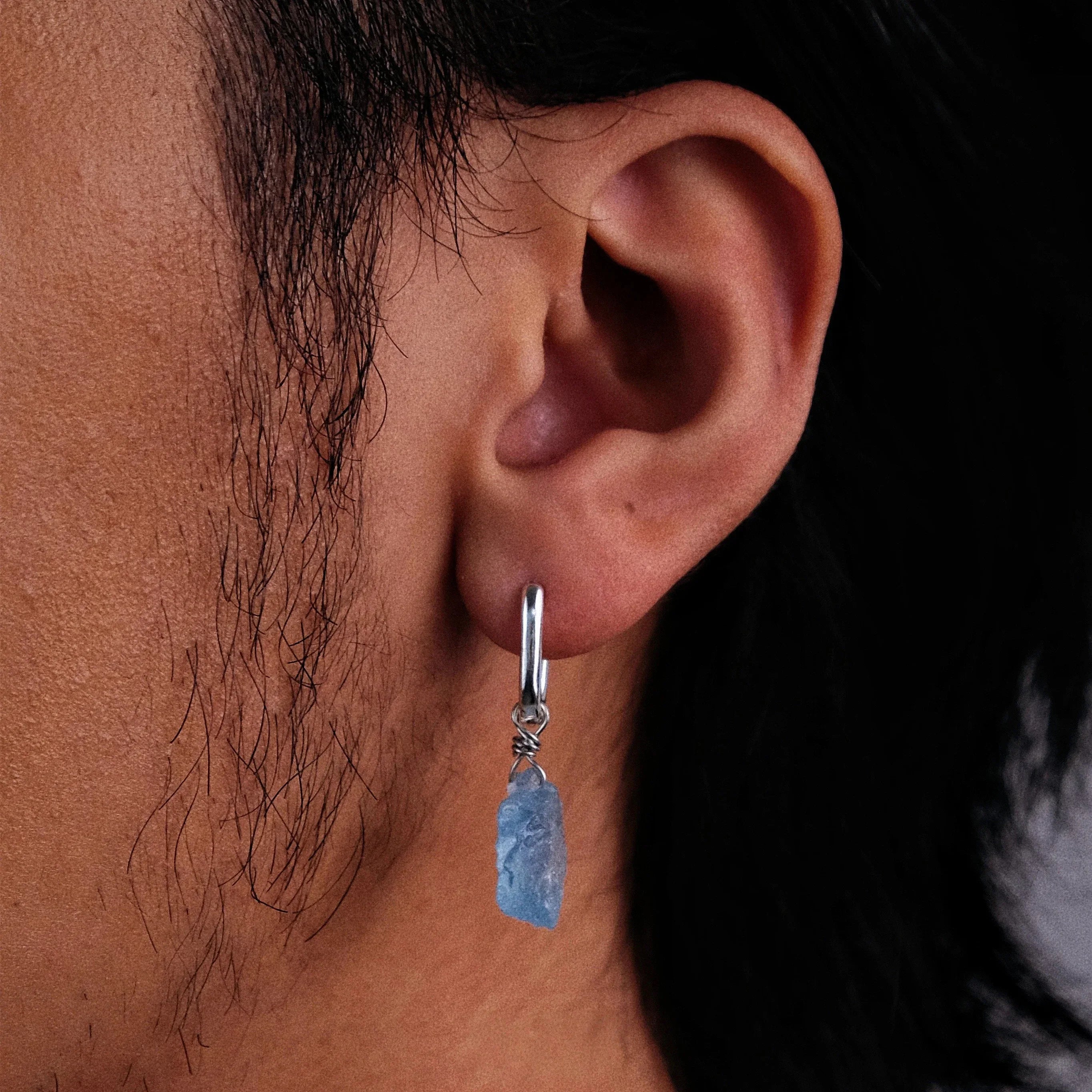 Raw Aquamarine Drop Earrings worn on the ear in a close-up