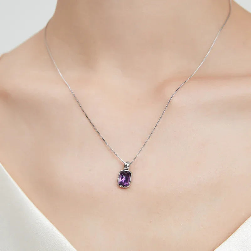 rectangular amethyst pendant necklace worn at the neckline in a close-up