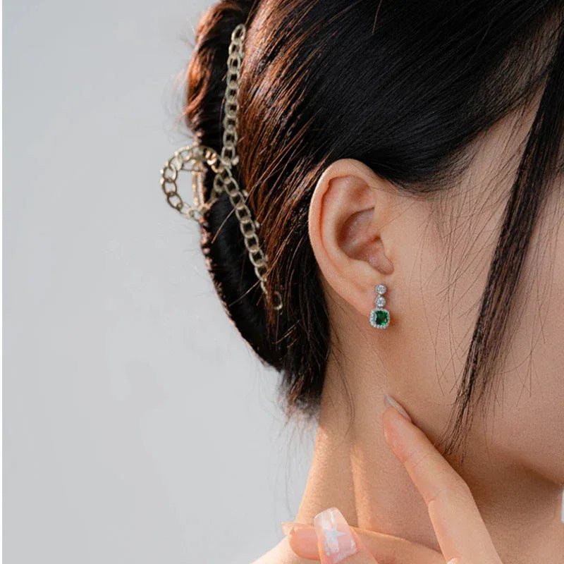 Rectangular Emerald Drop Earrings worn on the ear from a second angle