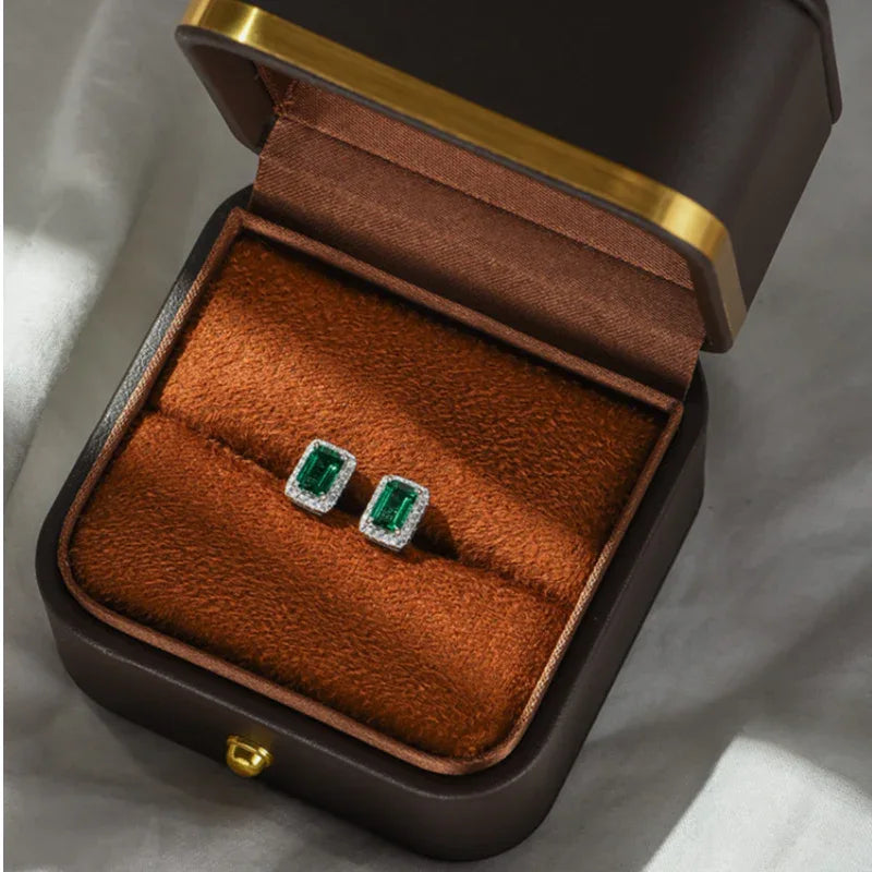 Rectangular Emerald Halo Stud Earrings styled ear view showing scale