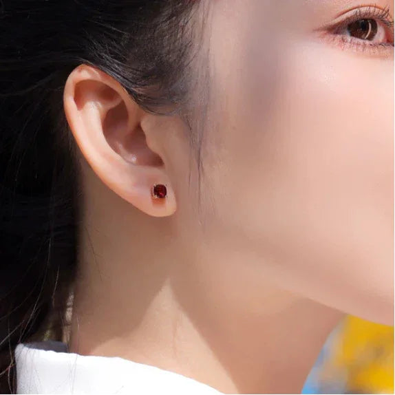 Rectangular Garnet Stud Earrings side view held between the fingers
