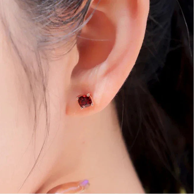 Rectangular Garnet Stud Earrings worn on the hand in a close-up
