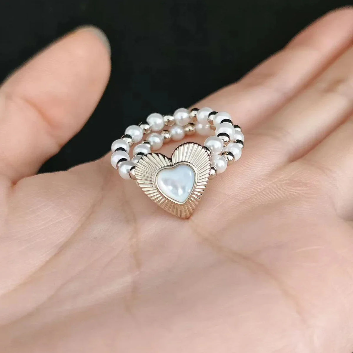 Triple-Row Pearl Heart Stretch Ring — second palm-held close-up