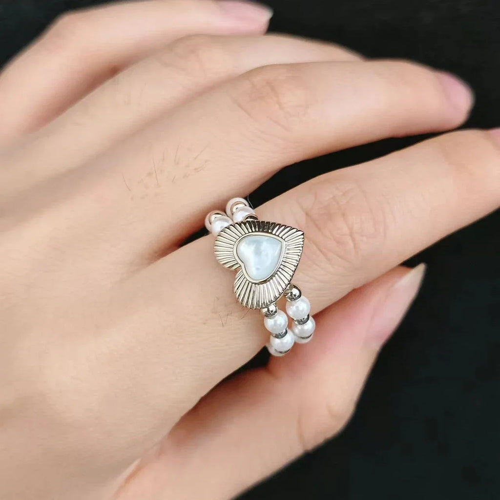 Triple-Row Pearl Heart Stretch Ring — ring held in the palm showing design and scale