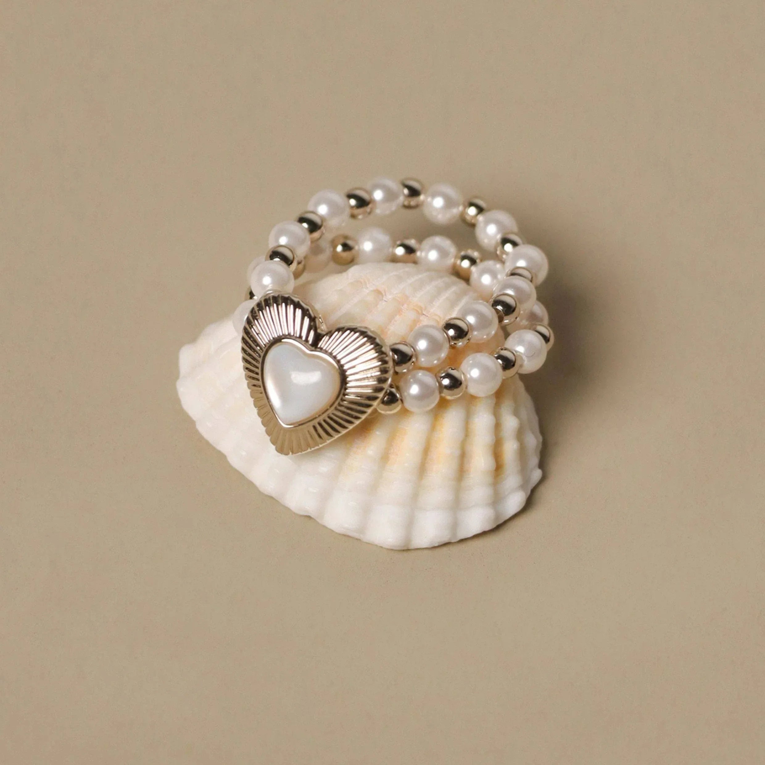 Triple-Row Pearl Heart Stretch Ring — angled display view showing the elastic bead rows