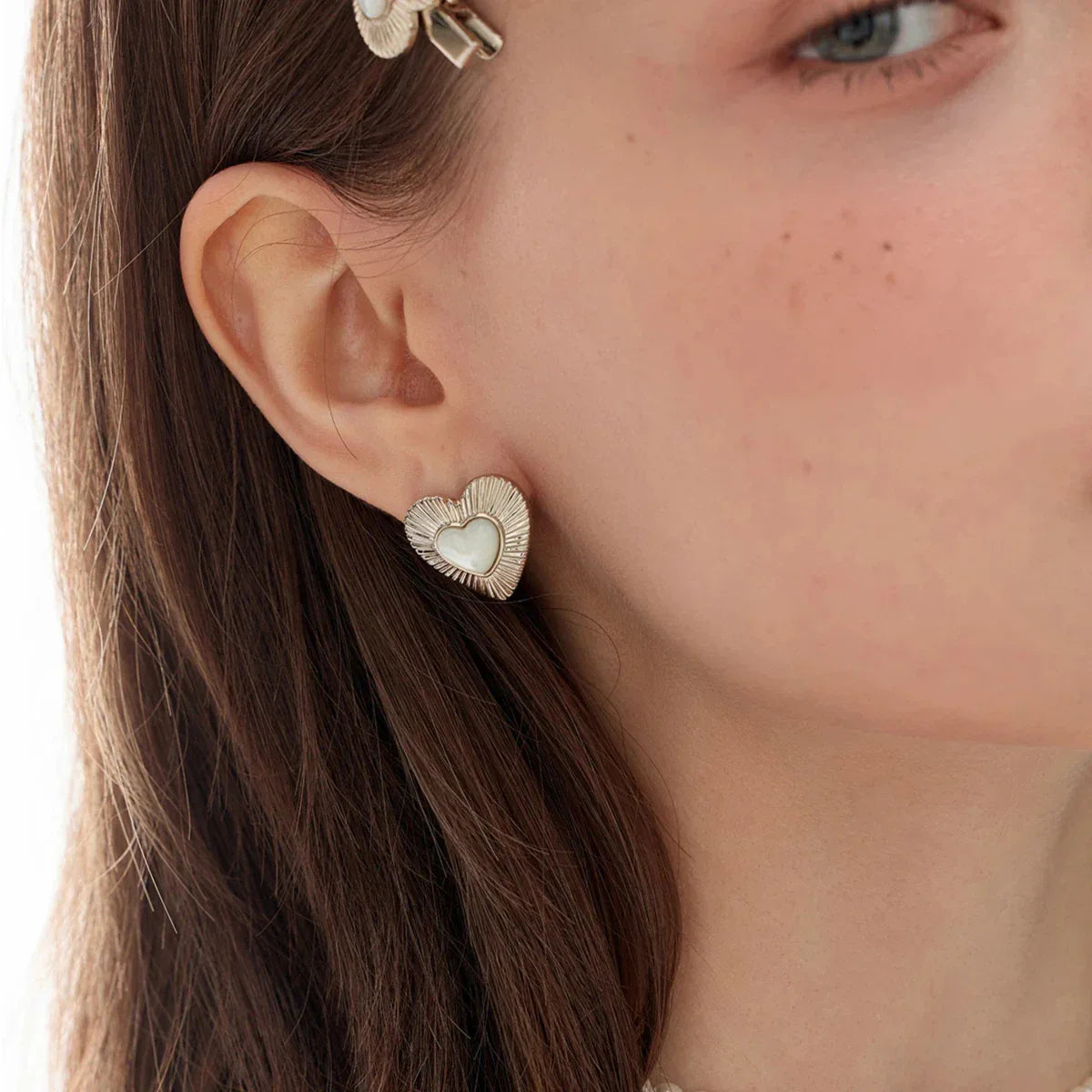 Ridged Pearl Heart Stud Earrings — right-ear worn close-up showing the bold heart scale