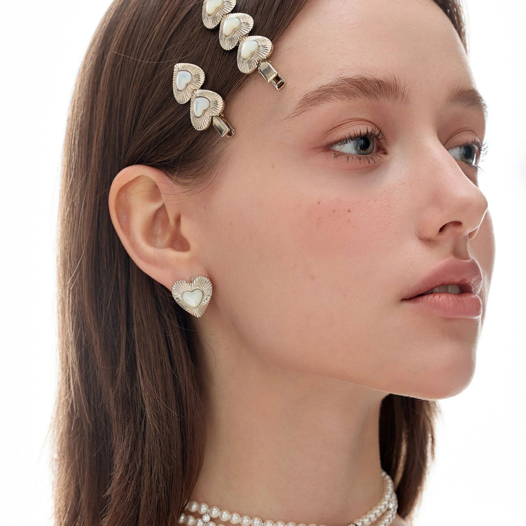 Ridged Pearl Heart Stud Earrings — side model portrait wearing the earrings