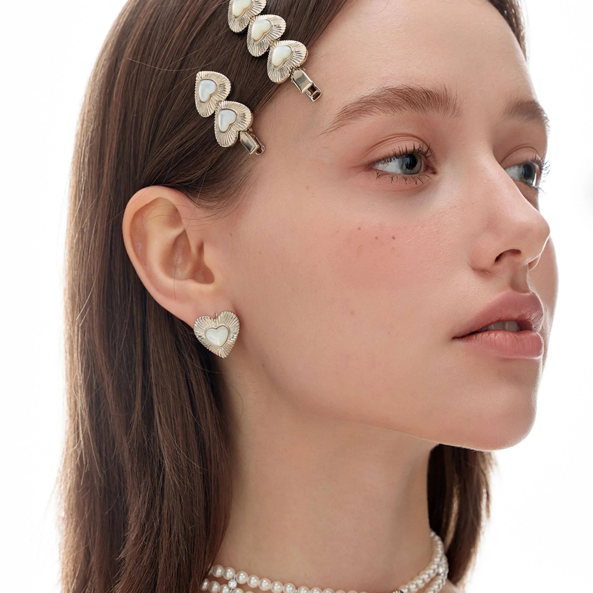 Ridged Pearl Heart Stud Earrings — side model portrait wearing the earrings