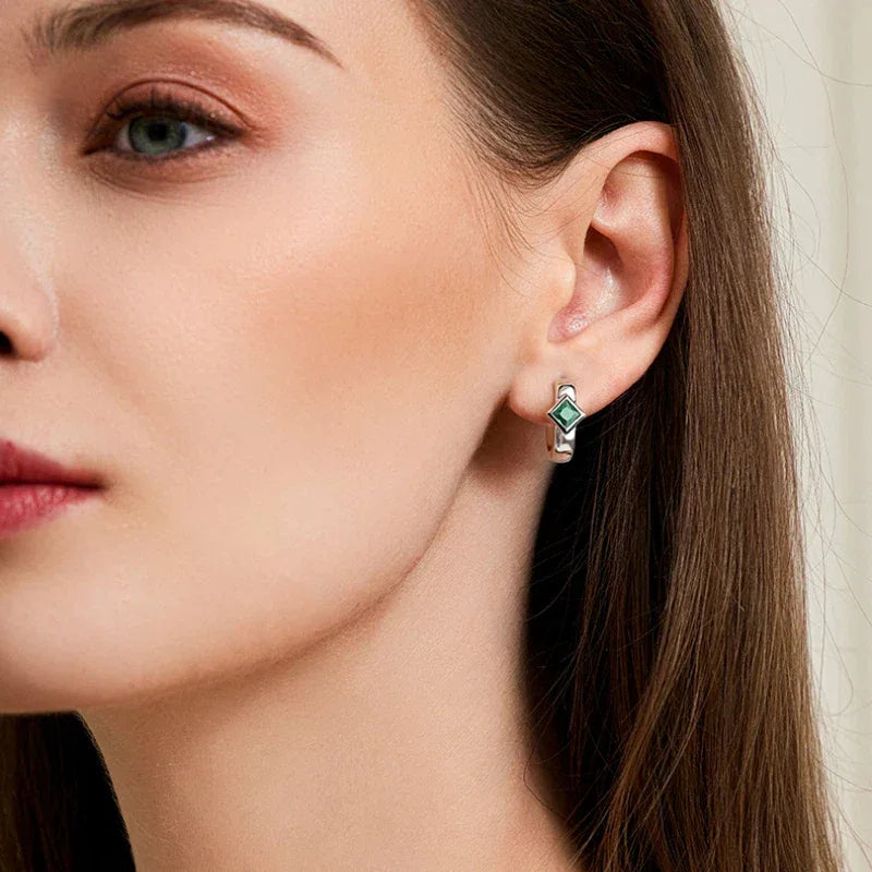 Rhombus Emerald Huggie Hoop Earrings worn on the ear from a second angle