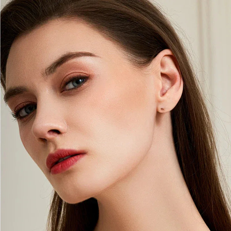 Rose-Purple Garnet Geometric Stud Earrings worn on the hand in a close-up