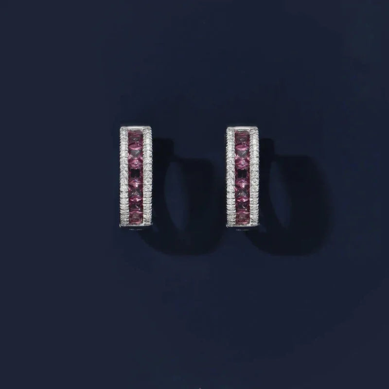 Rose-Purple Garnet Huggie Hoop Earrings worn on the hand from a second angle
