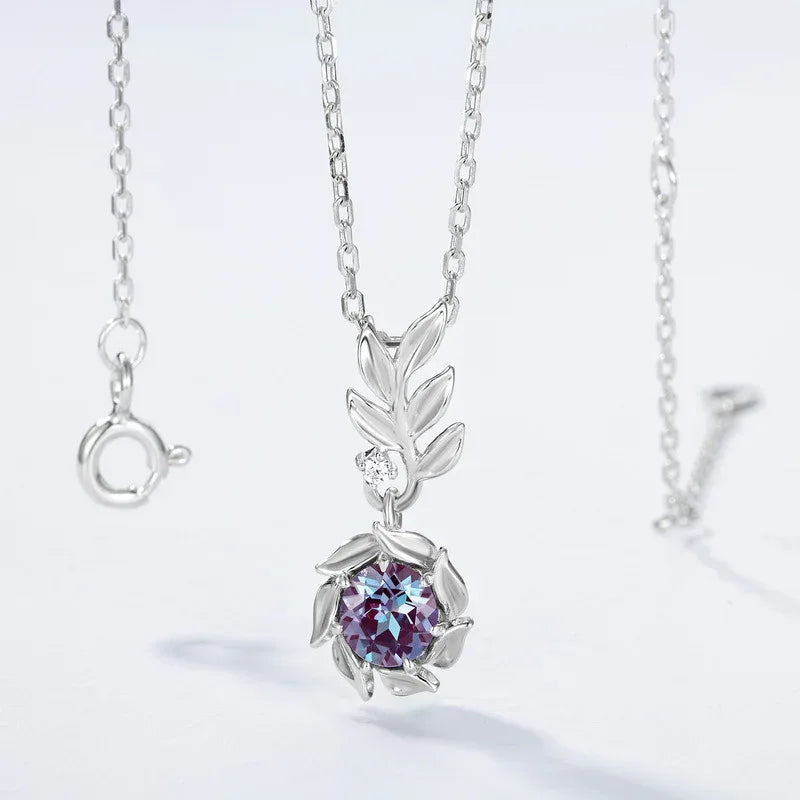 Round Alexandrite leaf drop necklace, product laid flat on a white background