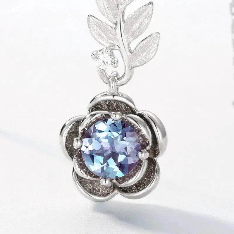 Round Alexandrite rose pendant necklace with a leaf connector, close-up showing the setting and decorative accents