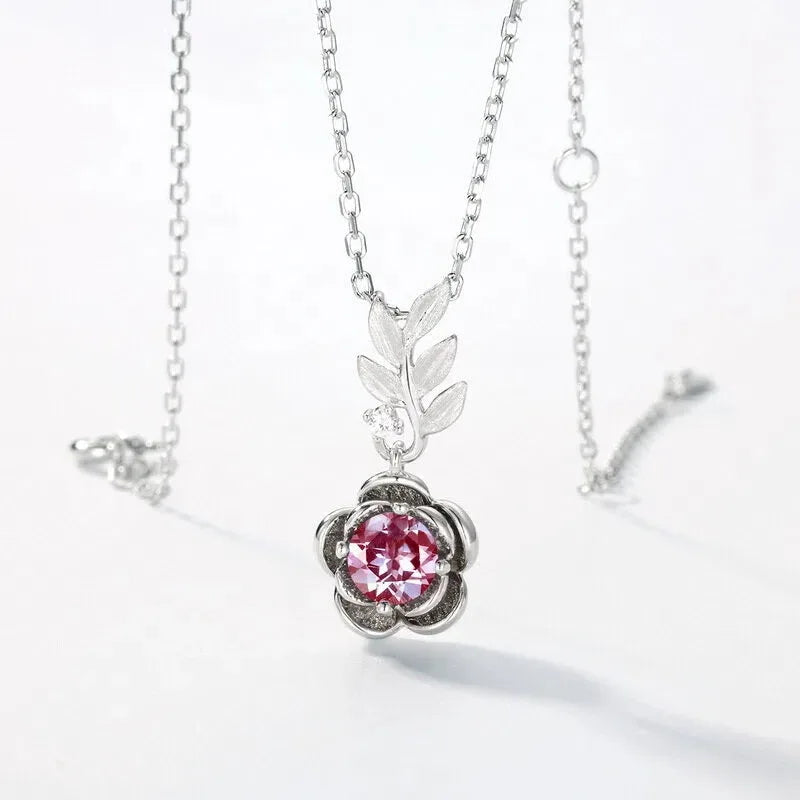 Round Alexandrite rose pendant necklace with a leaf connector, pink-toned Alexandrite view under alternate lighting