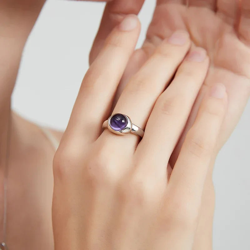 round amethyst bezel ring worn on the hand in a close-up