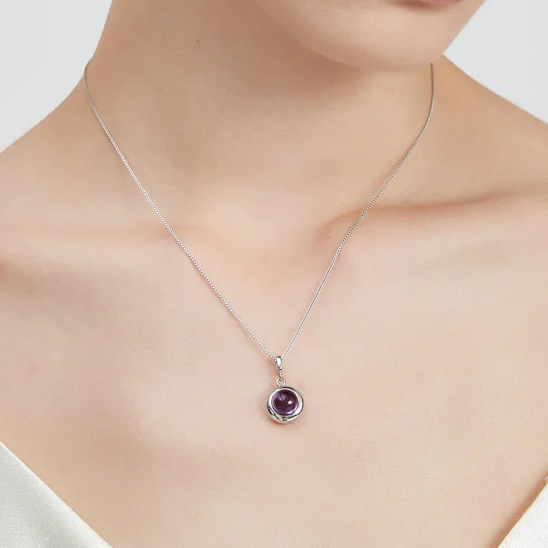 round amethyst bezel pendant necklace worn at the neckline in a portrait