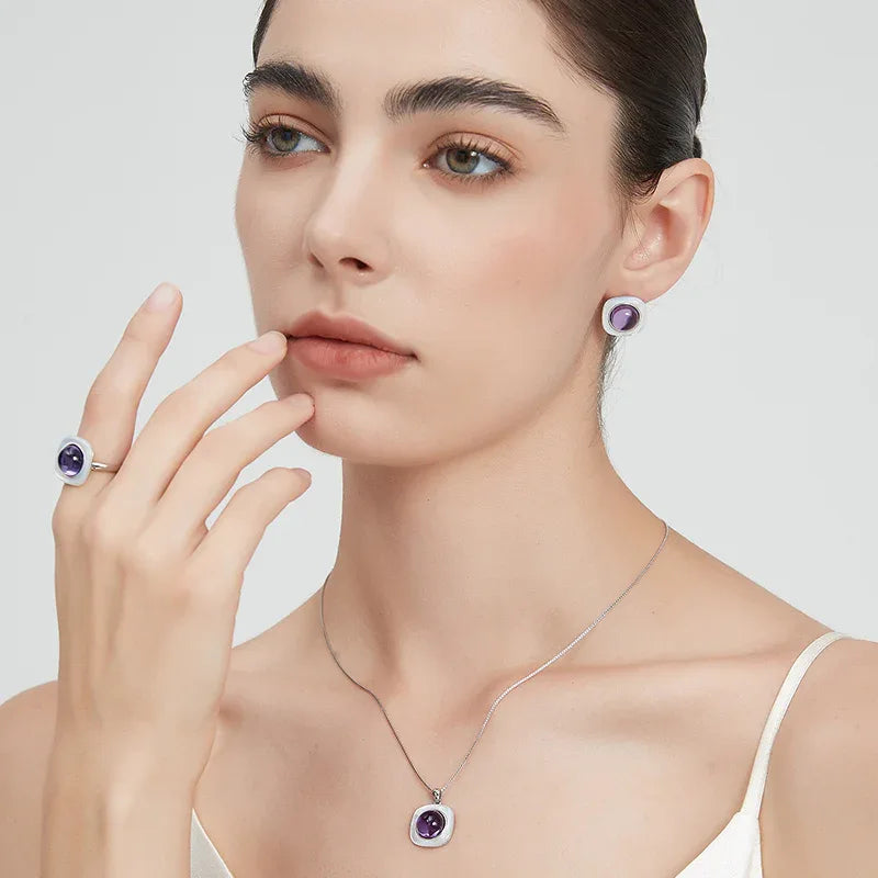 round amethyst stud earrings styled portrait showing the earrings for scale