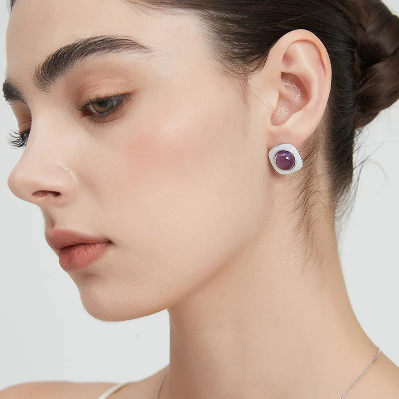 round amethyst stud earrings worn on the ear from a second angle