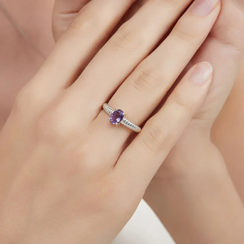 round amethyst open ring worn on the hand in a close-up