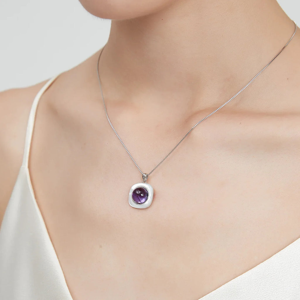 round amethyst pendant necklace worn at the neckline in a portrait