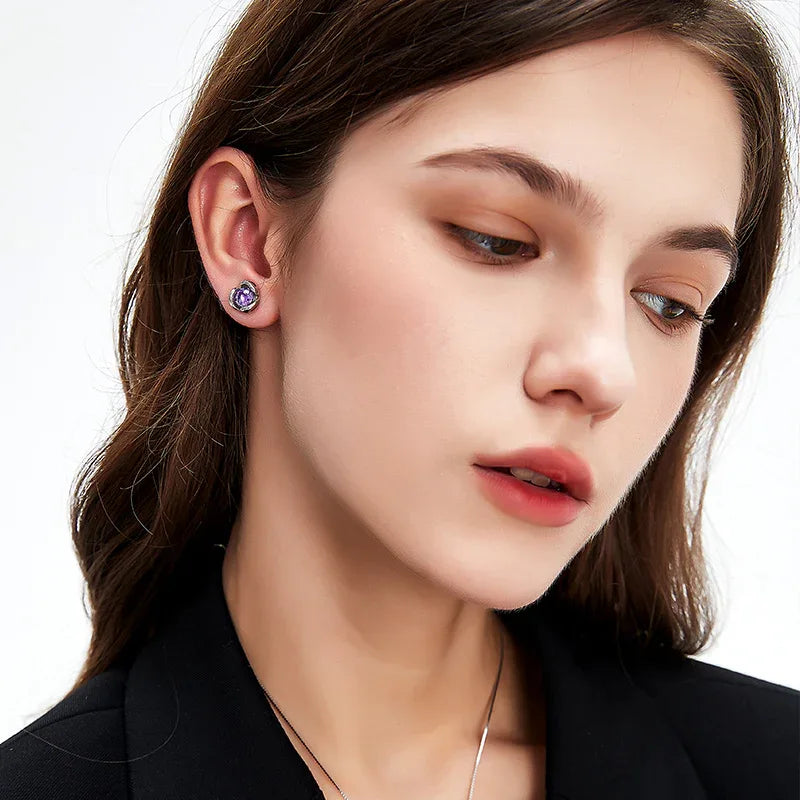 round amethyst stud earrings styled portrait showing the earrings for scale
