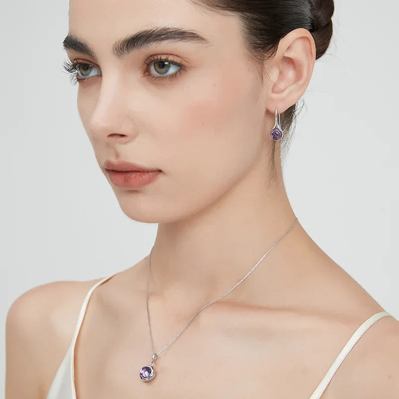 round amethyst drop earrings side portrait with the earrings