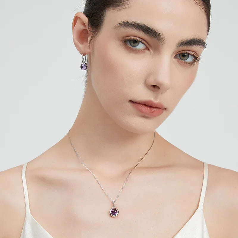 round amethyst drop earrings styled portrait showing the earrings for scale