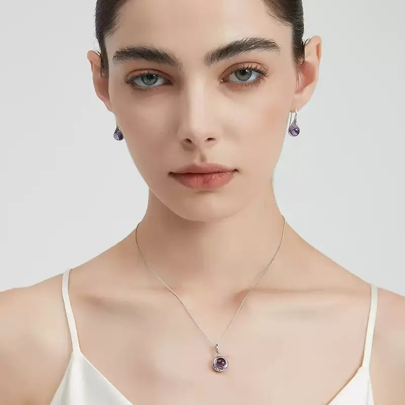 round amethyst drop earrings worn on the ear from a second angle