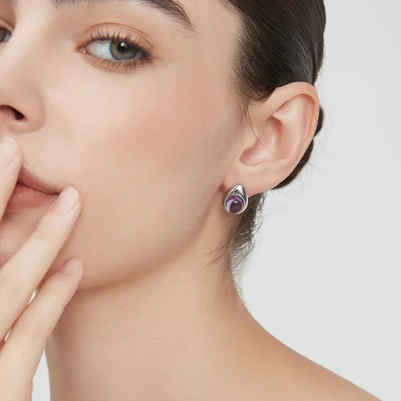 round amethyst stud earrings worn on the ear from a second angle