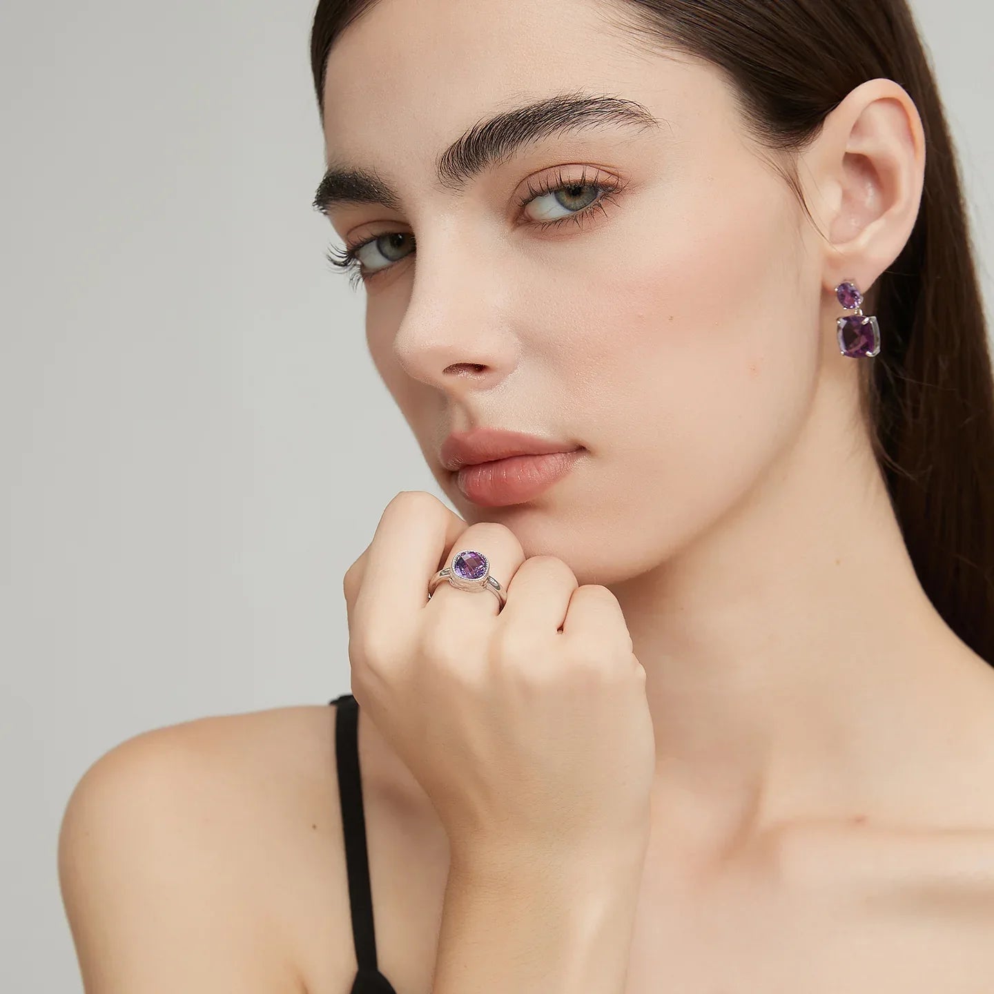 round amethyst halo ring worn detail beside the face