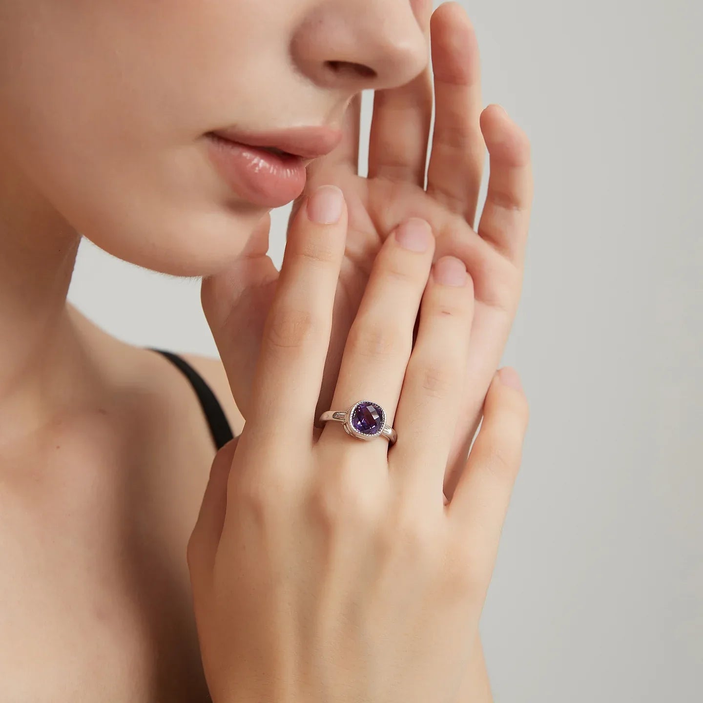 round amethyst halo ring worn on the hand from a second angle