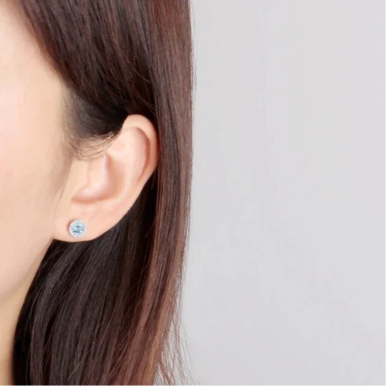 Round Aquamarine Halo Stud Earrings worn on the ear from a second angle