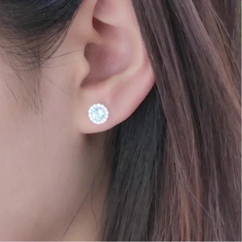 Round Aquamarine Halo Stud Earrings worn on the ear in a close-up