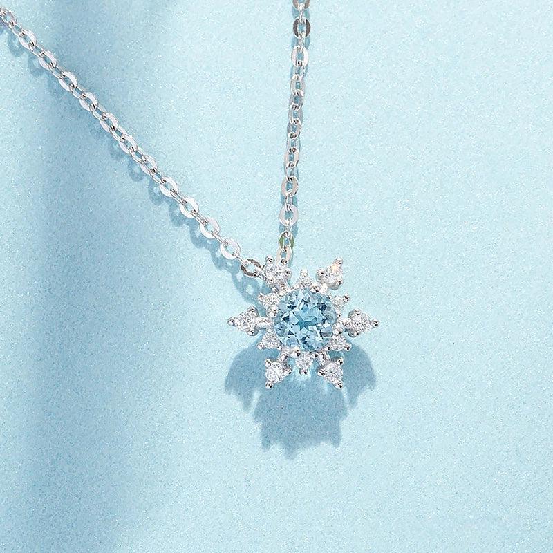 Round Aquamarine Snowflake Pendant Necklace pendant and chain detail on a light background