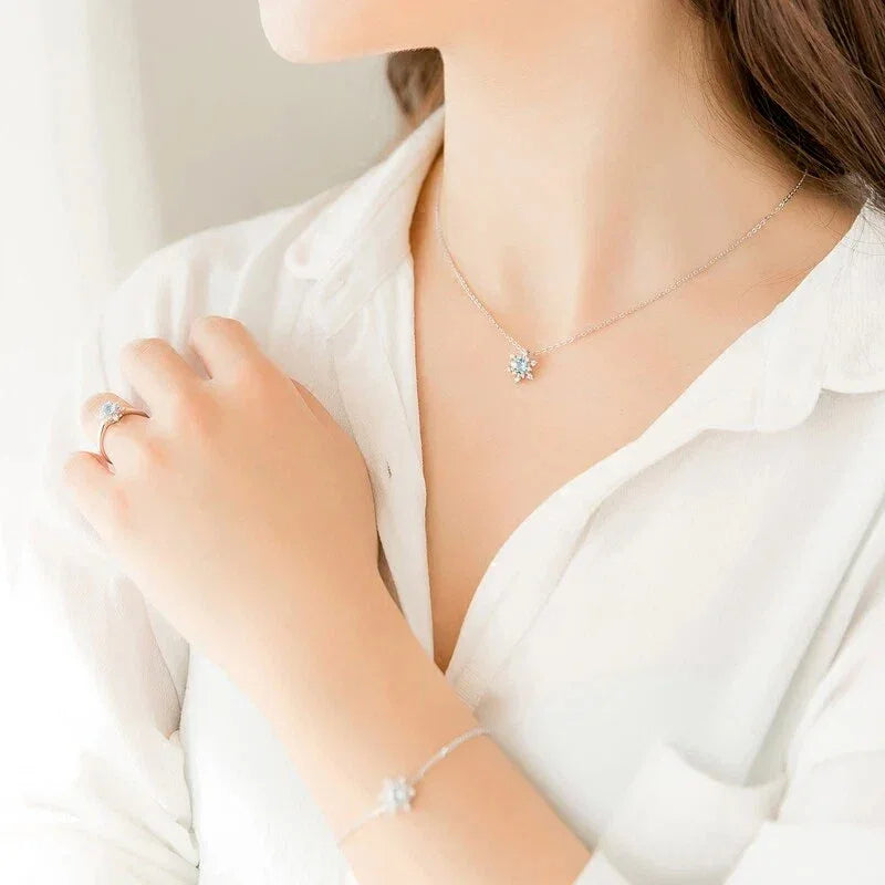 Round Aquamarine Snowflake Pendant Necklace worn at the neckline in a close-up
