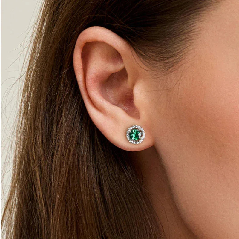 Round Emerald Halo Stud Earrings styled ear view showing scale