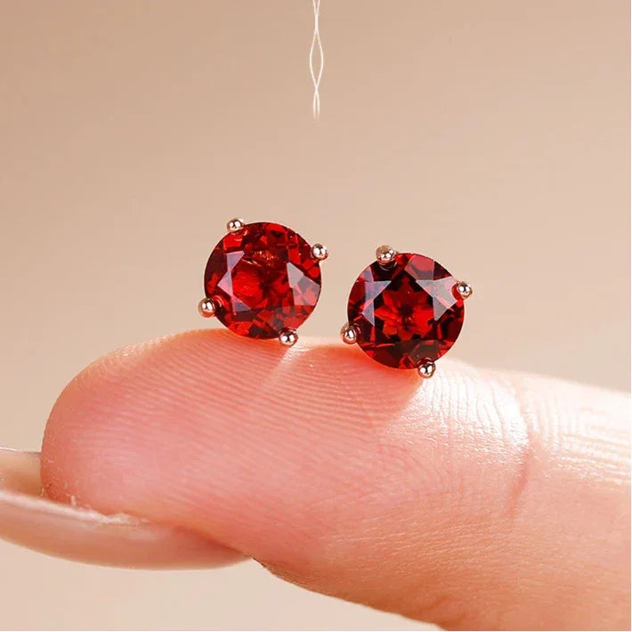 Round Garnet Four-Prong Stud Earrings angled product detail on a jewelry display