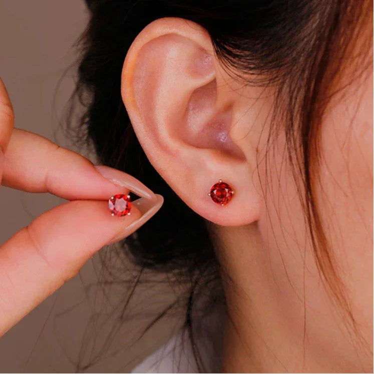 Round Garnet Four-Prong Stud Earrings worn on the hand from a second angle
