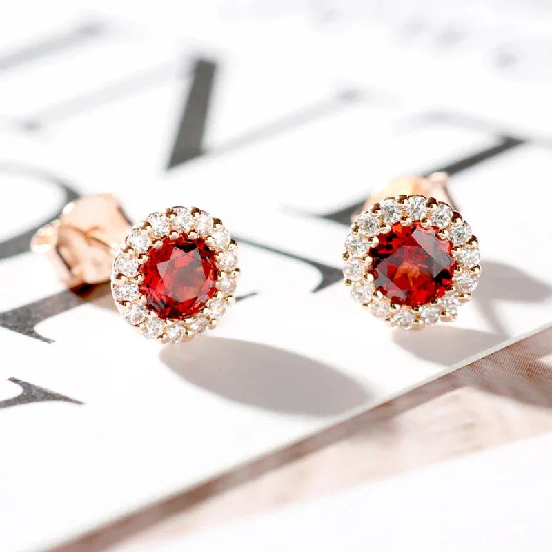 Round Garnet Halo Stud Earrings angled product detail on a jewelry display