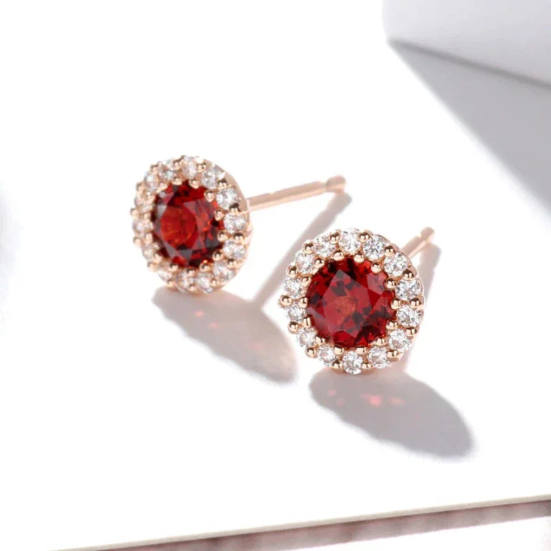 Round Garnet Halo Stud Earrings side view held between the fingers