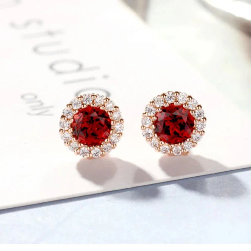 Round Garnet Halo Stud Earrings worn on the hand from a second angle